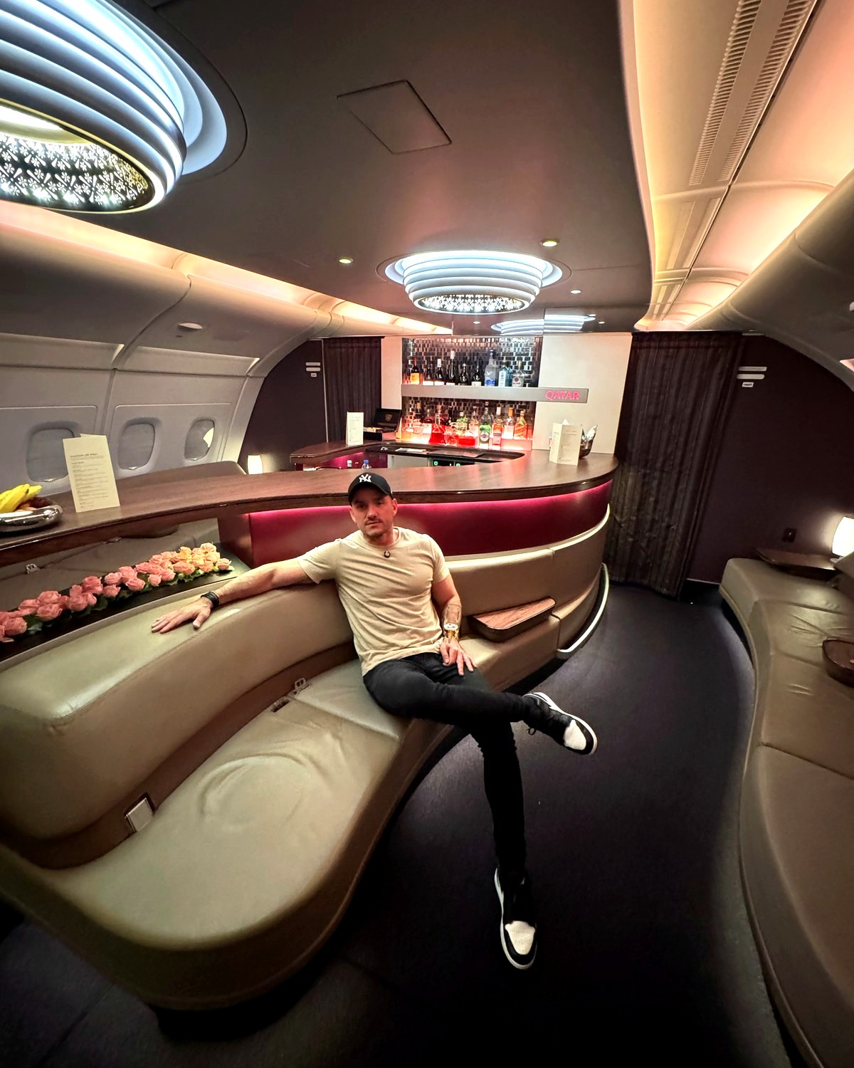 Adriano Brandão sentado no lounge do bar a bordo da classe executiva do Airbus A380 da Qatar Airways